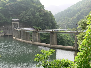 Vue de la digue côté lac du barrage depuis la rive droite