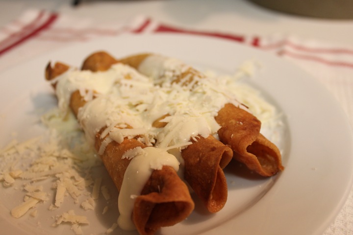 Flautas topped with creamy sauce 