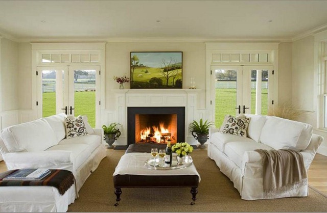 [eric roth living room white slipcovered sofas tufted leather ottoman casters turned wood legs fireplace mantel glass french doors[1][7].jpg]