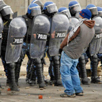 A protester urinates in front of a row of policemen during riots following the death of a 15-year-old boy in San Carlos de Bariloche June 18, 2010. According to local media, provincial government officials have confirmed that four police officers, involved in the incident which left the boy dead during an alleged robbery, have been removed from their posts. Three people have died and at least 12 have been injured during the clashes. Picture taken June 18, 2010. REUTERS/Alejandra Bartoliche (ARGENTINA - Tags: CIVIL UNREST CRIME LAW POLITICS IMAGES OF THE DAY)   FOR BEST QUALITY IMAGE: ALSO SEE GM1E6721UF901.F來㔓儴㕮ཿ㎬♴拫ሒ䪡睈ⴙ撺ᩪ