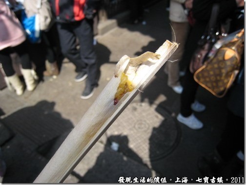 竹子的前頭原本還塞著荷葉，剖開後露出黃色的米飯，外面還包著一層竹膜。