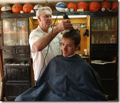 Jesse Joyner, an Asbury Seminary student gets his haircut, Friday, April 16, 2004, by Clay Tankersley, of Clay's Barbershop in downtown Wilmore. Tankersley has been cutting hair in the same location in since 1956.(Photo by Tim Webb, April 16, 2004)