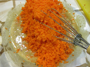 photo of the grated carrots being added to the batter