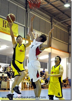 Lim Thin Teck (L) of the veteran national basketball team going for a layup against Huong Yu Hua (R) of Miri during their match for the 11th Borneo City Veteran Basketball Invitation Tournament 2010 last night.Picture: BT