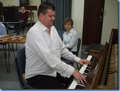 Chris Larking playing the piano whilst fellow pianist Denise Gunson watches on with interest