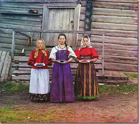 Peasant girls, Russian Empire. Three young women offer berries to visitors to their izba, a traditional wooden house, in a rural area along the Sheksna River, near the town of Kirillov; 1909
Sergei Mikhailovich Prokudin-Gorskii Collection (Library of Congress).