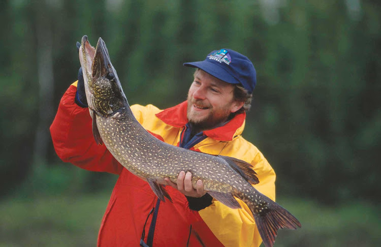 A fisherman shows off the pike he caught in Abitibi-Temiscamingue, Quebec, Canada.
