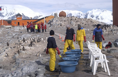 Departing passengers line up to get the bottom of their boots scrubbed with disinfectant to wash off the penguin poop, which you definitely don't want to be tracking into your cabin!