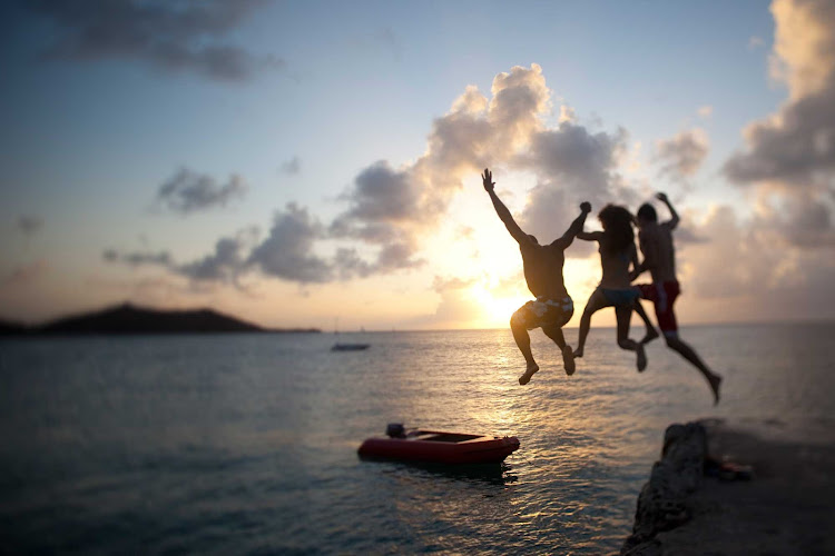 As the sun sets on St. Maarten, visitors take one last leap into the sea.