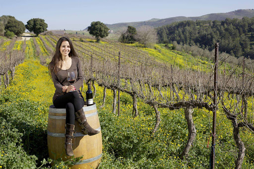 A woman kicks back amid the vineyards of a winery in Israel.