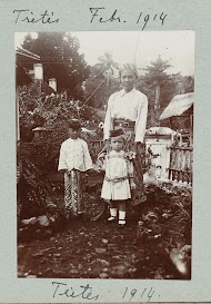 Een man in balinese kleding met twee kinderen.
