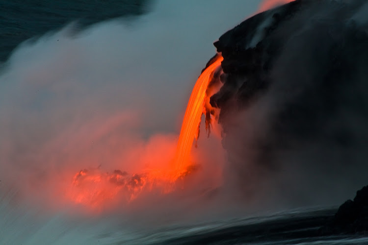 Lava enters the sea at dusk at Pahoa on the Big Island of Hawaii. 