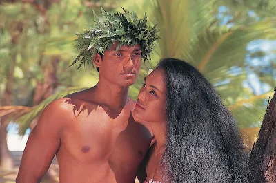 A Tahitian couple in traditional dress are about to greet visitors to their island.