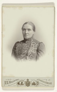 Studioportret van een vrouw in een zwarte, hooggesloten jurk