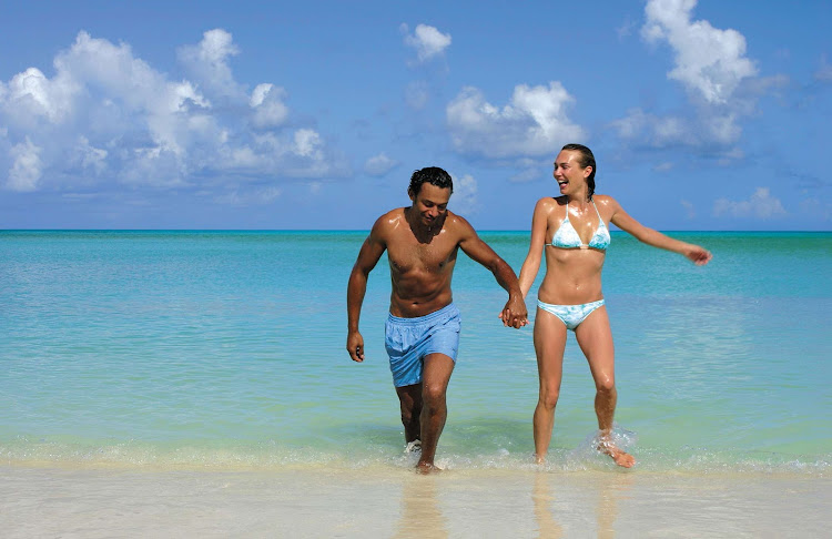 A couple frolics in the warm afternoon surf at the Jolly Beach Resort in Antigua and Barbuda.