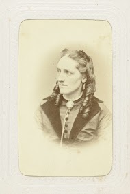 Portret van een vrouw in een hooggesloten jurk met lang haar met pijpenkrullen