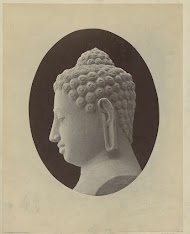 Beeld van een Boeddha hoofd en profilemet zijn haar in krullen die zijn ushnisha bedekken.