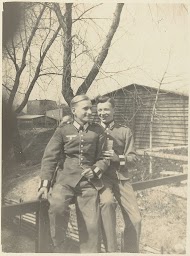 Twee leden van de Wehrmacht op een hek