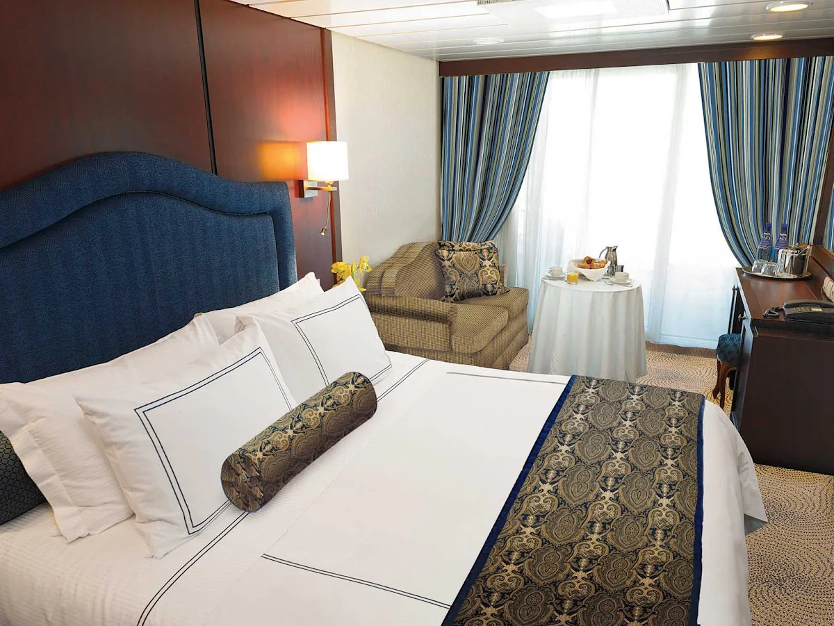 Oceania-B-Veranda-Stateroom-2 - Oceania Insignia's Veranda stateroom offers a private teak veranda for taking in panoramic views, a queen bed with 1,000-thread-count linens, a vanity desk, refrigerated mini-bar, breakfast table and spacious seating area. It's located mid-ship on deck 6 and is 216 square feet.