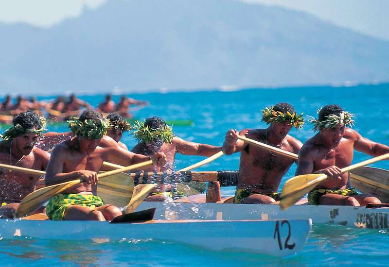 Tahitian outrigger races feature paddlers dressed in colorful pareos and traditional 