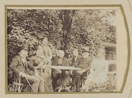 Portret van een gezin aan een tuintafel met hond