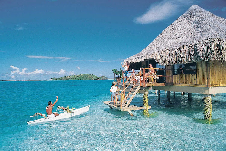 A canoeist approaching a visitor's bungalow at the InterContinental Bora Bora Le Moana Resort.