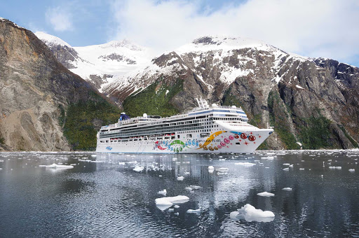 Norwegian-Pearl-Aerial-Alaska-4 - Norwegian Pearl cruising in Alaska waters against a backdrop of rugged coastline and snow-capped peaks.