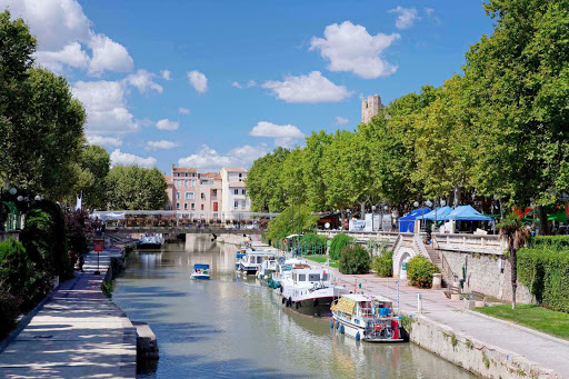 Boats and paths along Canal de la Robine in the middle of Narbonne in the Languedoc-Roussillon region of southern France. 