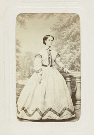 Studioportret van een jonge vrouw in een lange jurk met stippen