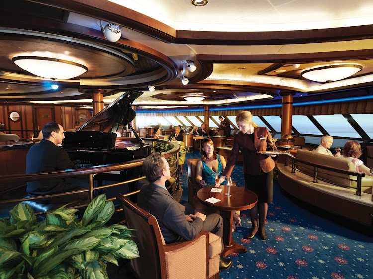 Enjoy your favorite martini or cocktail with panoramic views over the bow of the ship at the Commodore Club aboard Queen Victoria.