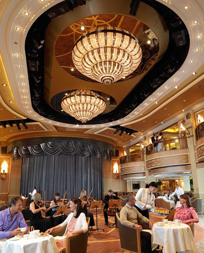 A view of the elegant Queens Room ballroom aboard Queen Elizabeth, where white-gloved waiters serve cucumber sandwiches, scones and tea accompanied by orchestral music.