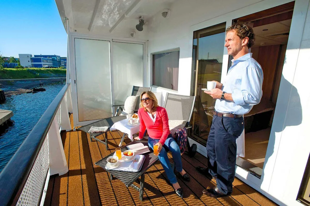 Viking-River-Cruises-couple-on-veranda - Spend your morning soaking in the views with a continental breakfast on your private veranda aboard your Viking Cruises ship during her sailing in Russia. 