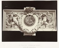 Reliëf met engeltjes naast een medaillon, samen houden zij een fruitslinger vast.