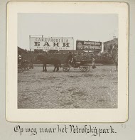 Rij van rijtuigen met passagiers, stilstaand voor reclameborden